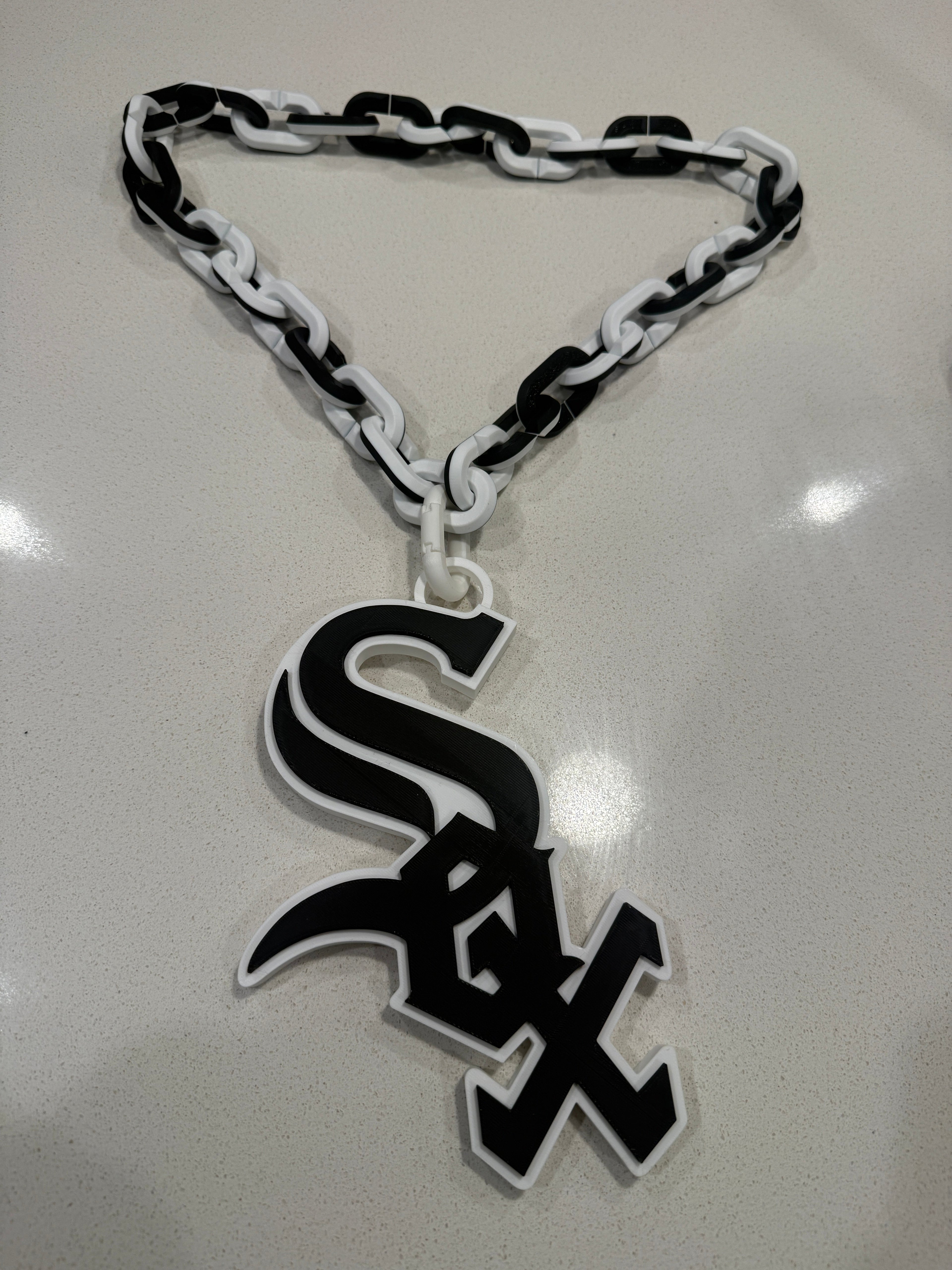 Black and white chain with a logo on a reflective surface